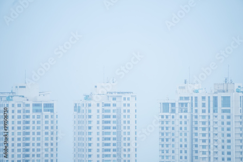 Morning in the North Jakarta City with many tall buildings, settlements and smog due to air pollution. Poor air quality in the Jabodetabek area. Concept for global warming and climate change. photo