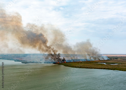 Wildfire by a lake with a lot of smoke