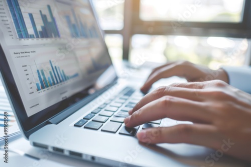 Close-up of hands typing on a laptop with financial graphs displayed on the screen. Business and financial analysis concept. Design for poster, header, banner, website.