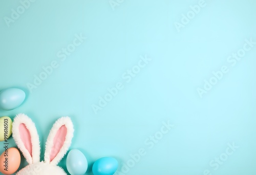 Easter rabbit flaffy ears and row of colored easter colored eggs on blue background, top view with copy space
 photo