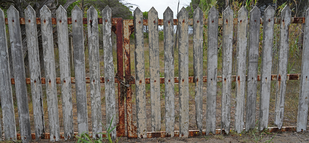 Obraz premium Old wooden fence with a lock in front