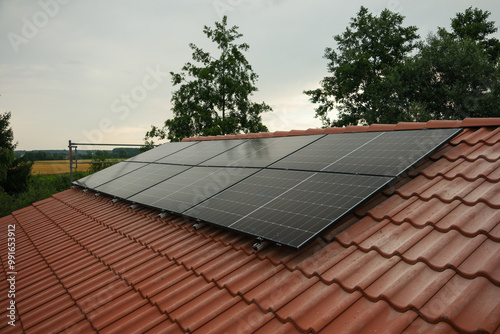 Black solar panels on a red tile roof