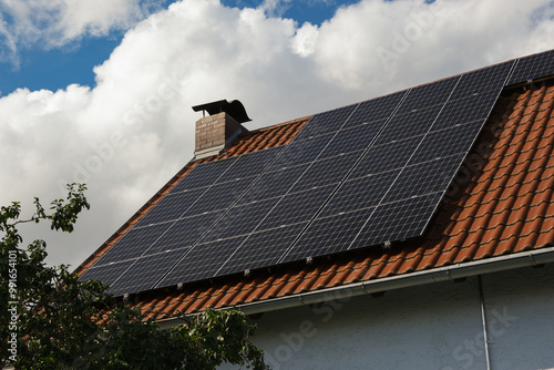 Black solar panels on a red tile roof