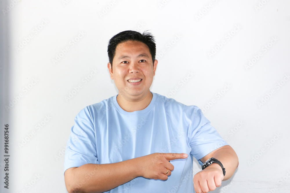 Handsome Asian man looking at his watch with happy face. On time concept. Handsome Asian man looking at his watch with happy face. On time concept.