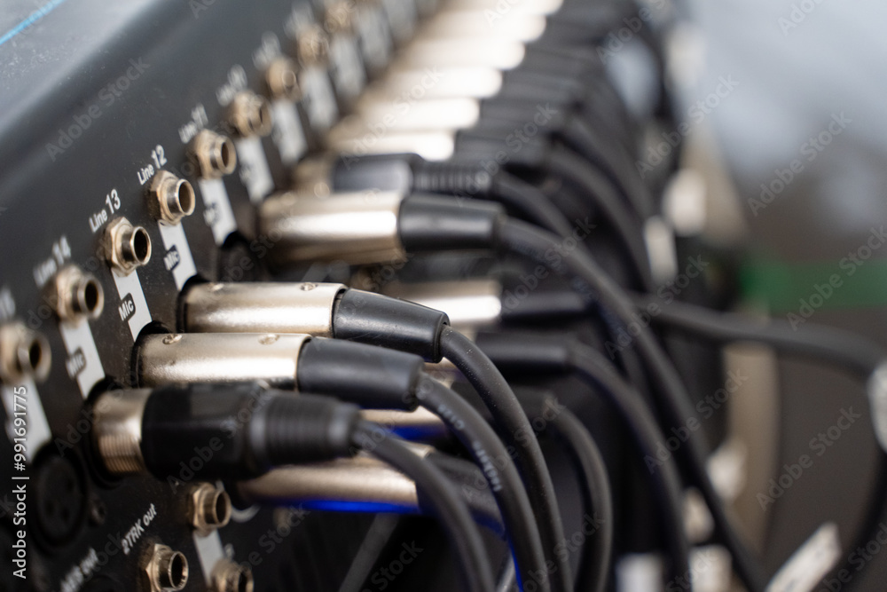 A closeup view of intricate audio mixer connections, highlighting various cables and connectors vital for professional sound equipment A closeup view of intricate audio mixer connections, highlighting various cables and connectors vital for professional sound equipment
