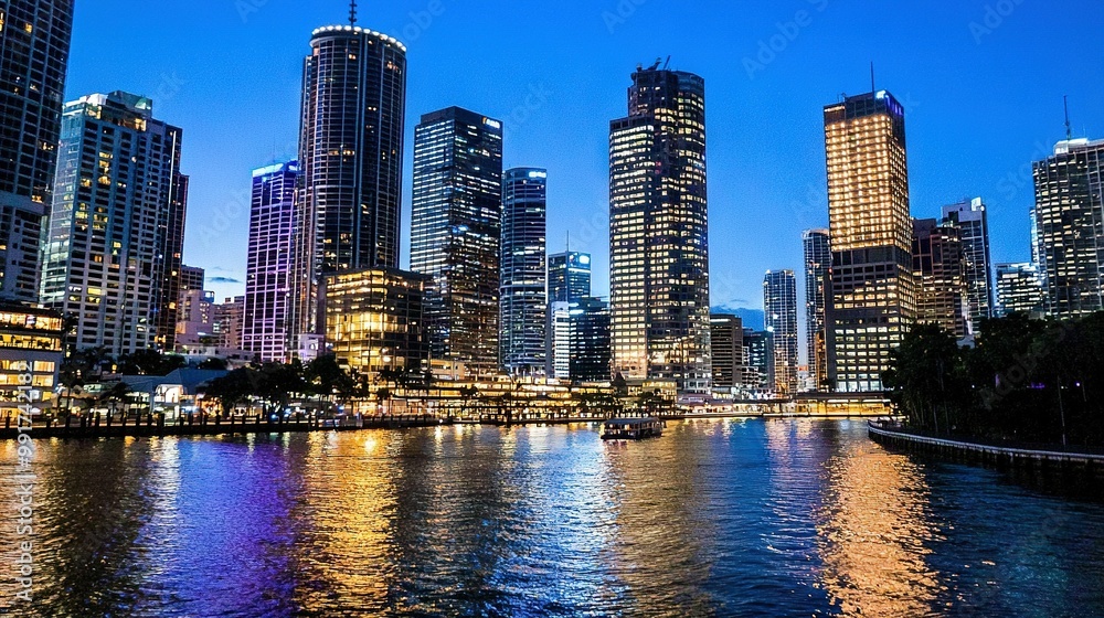 Naklejka premium A vast expanse of water with towering edifices behind it and a vessel upfront