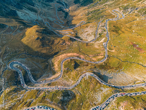 Aerial view of the Transfagarasan highway, highlighting the contrast of cars against the vibrant autumn trees. photo