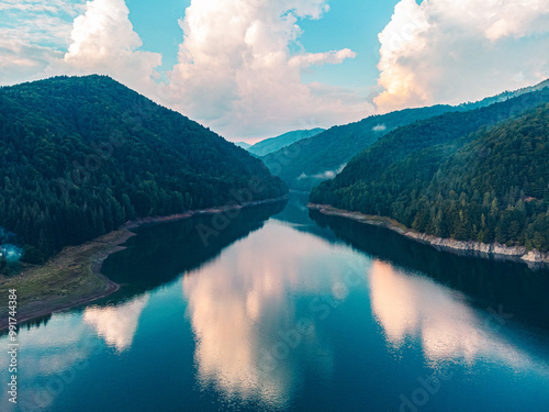 Aerial view capturing the golden hour over a mountain lake, with stunning reflections and surrounding peaks.
