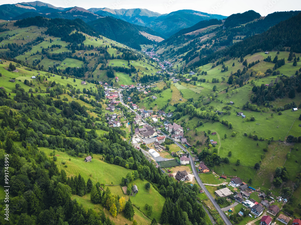 Aerial view of a panoramic landscape surrounded by mountains on the horizon, featuring lush green meadows. Aerial view of a panoramic landscape surrounded by mountains on the horizon, featuring lush green meadows.