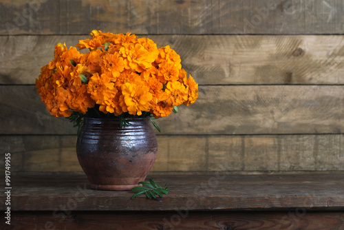 Bild auf Leinwand bouquet of marigolds in a clay jug on a dark wooden background