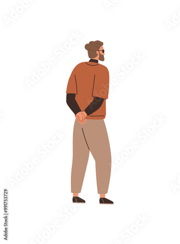 Man standing with hands clasped behind his back in a relaxed posture. Wearing casual autumn attire, indicating a pensive mood. Ideal for themes contemplation, casual fashion, relaxation, autumn