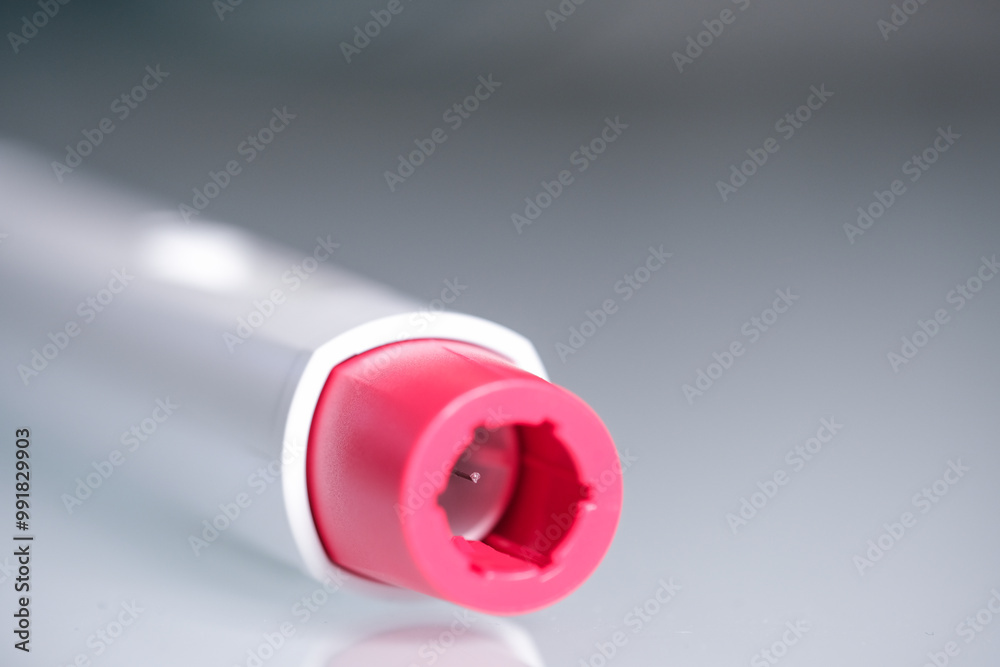 Detail of the head of a pen injector with a red tip for biological treatments such as Adalimumab, Etanercept or epinephrine. The background is aseptic, clean, white and well lit. Detail of the head of a pen injector with a red tip for biological treatments such as Adalimumab, Etanercept or epinephrine. The background is aseptic, clean, white and well lit.