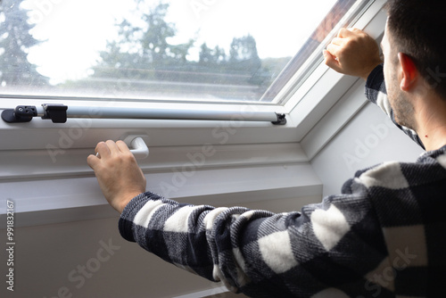 man´s hands holding a door handle of a glass door. opening or closing doors at home. plastic windows in appartment. switching windows to autumn-winter mode, insulating an apartment. seasonal cold snap photo