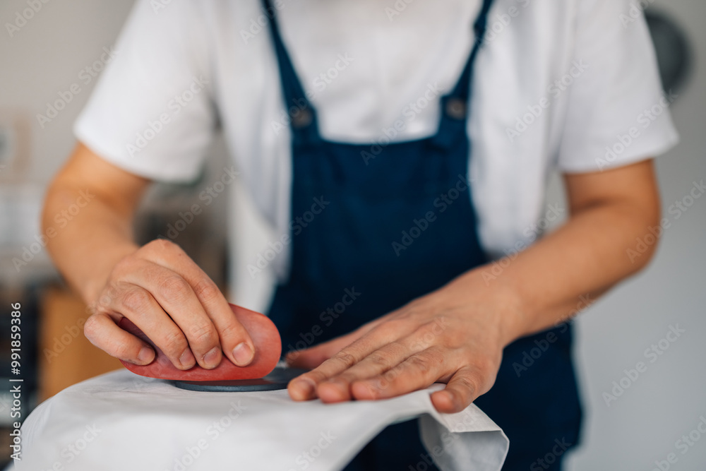 Close up of pottery designer's hands flattening wet clay surface. Close up of pottery designer's hands flattening wet clay surface.