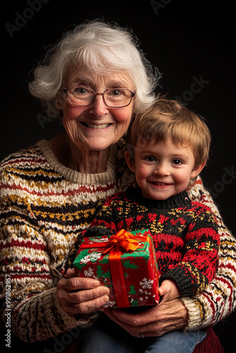 modern photo of a granny and child dressed with a christmas sweater holding a present, smiling photo