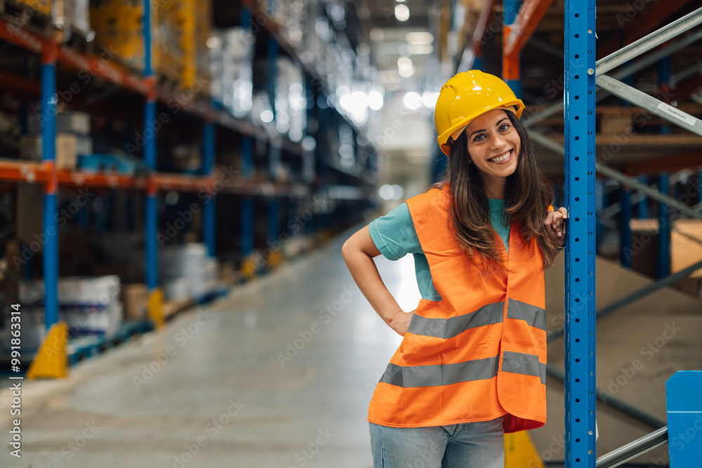 Smiling female warehouse worker posing with scaffolding in background Smiling female warehouse worker posing with scaffolding in background
