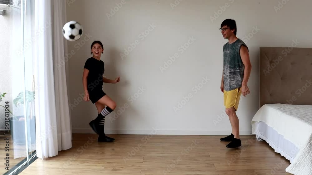Pai e filha jogando futebol em casa Pai e filha jogando futebol em casa