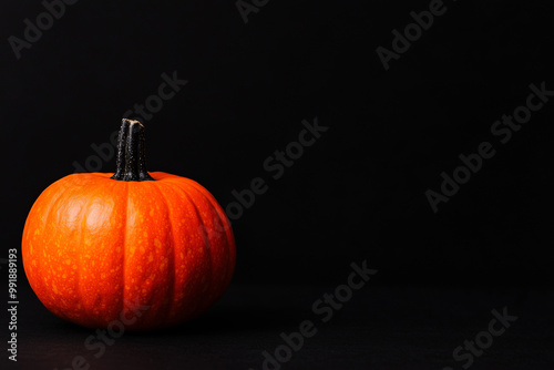 Vividly hued orange pumpkin set against a dark backdrop, evoking a haunting and celebratory ambiance photo