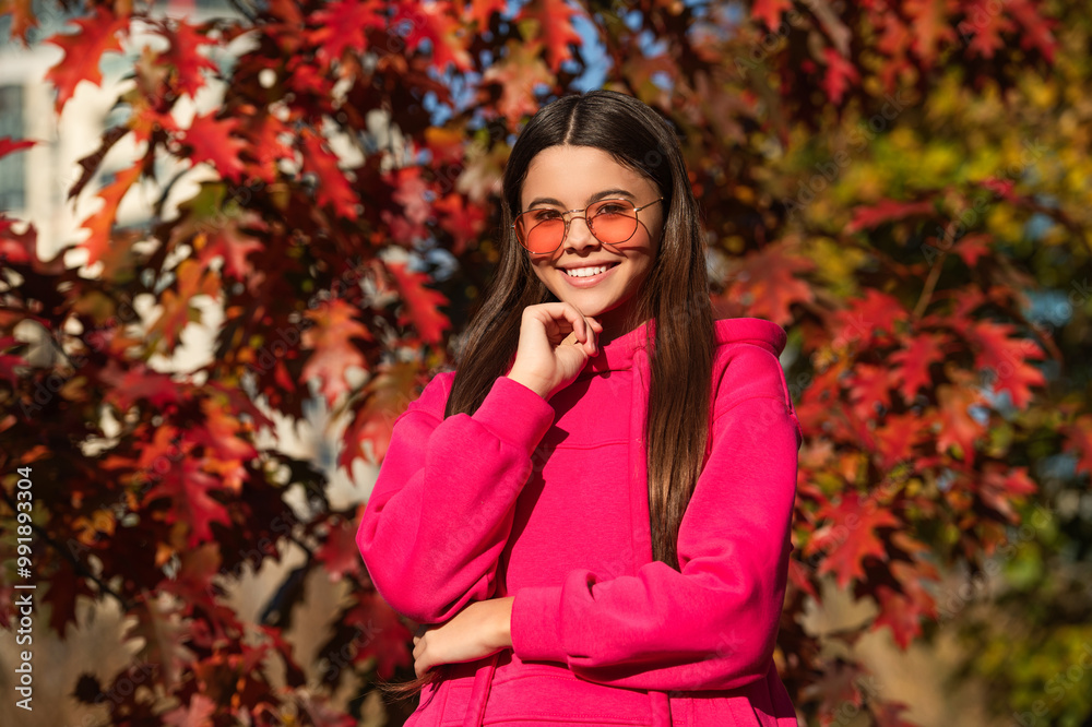 Fall style fashion. Autumn leaves and happy young girl in forest. The color and mood of autumn. Teenager girl in the autumn park. Fall concept. Girl in autumn style outdoor. Sunny weather Fall style fashion. Autumn leaves and happy young girl in forest. The color and mood of autumn. Teenager girl in the autumn park. Fall concept. Girl in autumn style outdoor. Sunny weather