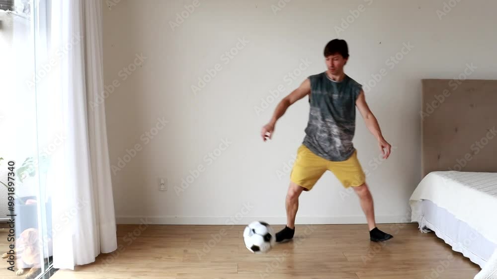 homem jogando futebol com bola em casa homem jogando futebol com bola em casa