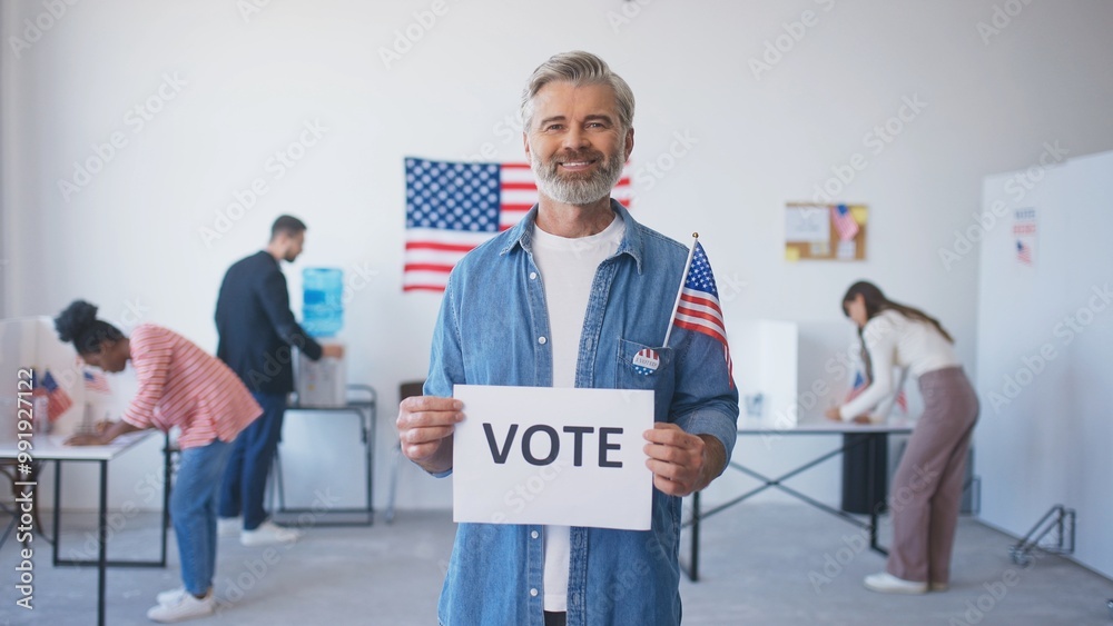 Attractive Caucasian male with grey hair and beard looking directly at camera while smiling. Holding piece of paper saying Attractive Caucasian male with grey hair and beard looking directly at camera while smiling. Holding piece of paper saying