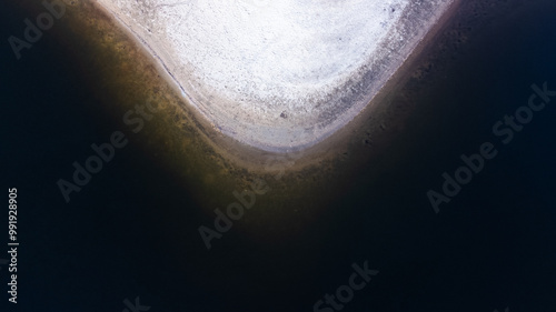 Quadro em tela Plage de sable se jetant dans le lac dont l'eau est très sombre