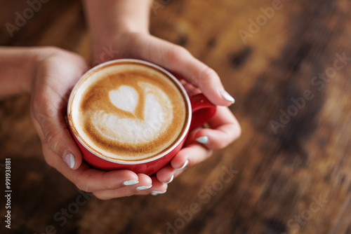 Close-up image of a cup of coffee held in hands. Nothing like a good coffee to start the day. Hand-roasted coffee, authentic coffee. A dose of caffeine. Portrait photo