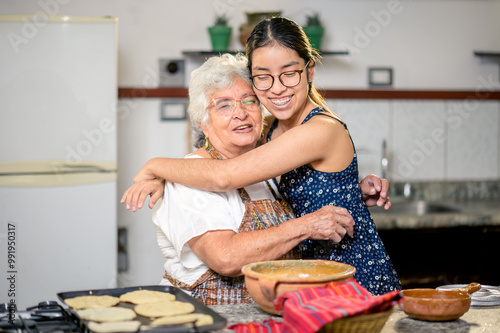 Portrait of a Latina grandmother and granddaughter hugging each other.