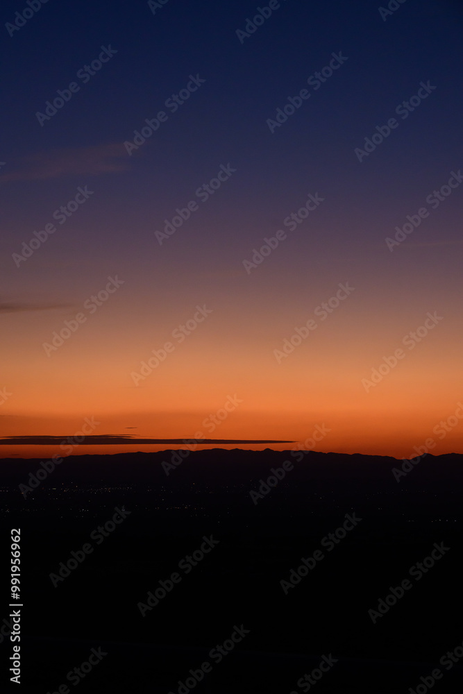 Vertical shot of a natural landscape with the city in the distance, glowing in the sunset. Vertical shot of a natural landscape with the city in the distance, glowing in the sunset.