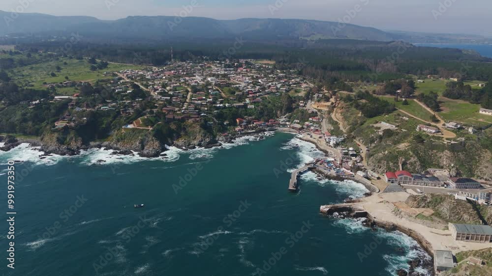 Aerial view showcasing the coastal fishing village of Caleta Quintay in Paine, Santiago Metropolitan Region, Chile, perched on rugged cliffs with waves crashing below. Aerial view showcasing the coastal fishing village of Caleta Quintay in Paine, Santiago Metropolitan Region, Chile, perched on rugged cliffs with waves crashing below.