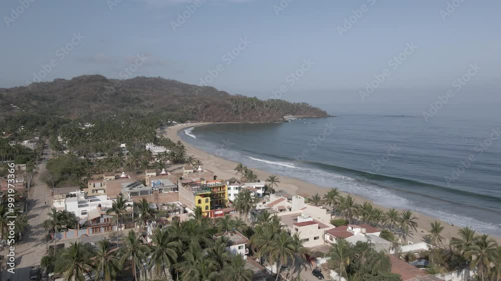 Ocean waves wash onto crescent sand beach at Lo de Marcos, Mexico