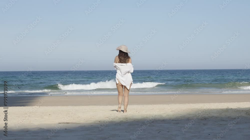 Girl at the beach, Beautiful young woman beachwear walking toward ocean Girl at the beach, Beautiful young woman beachwear walking toward ocean