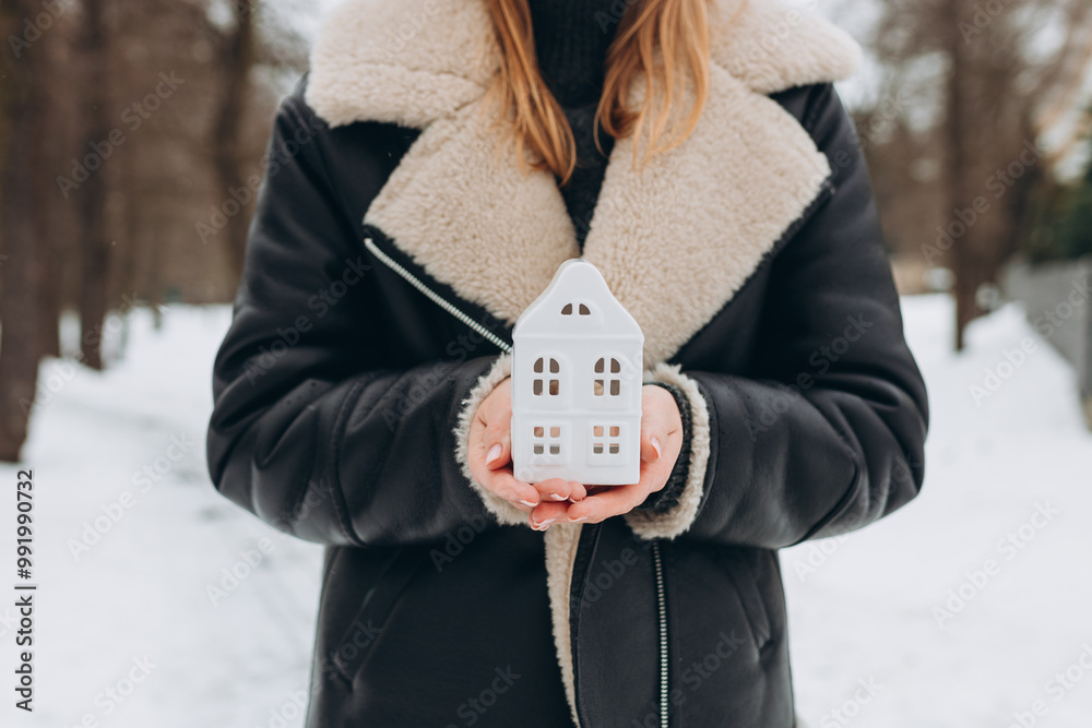 close up of hands holding white ceramic house. Family, building, construction, real estate and safety concept