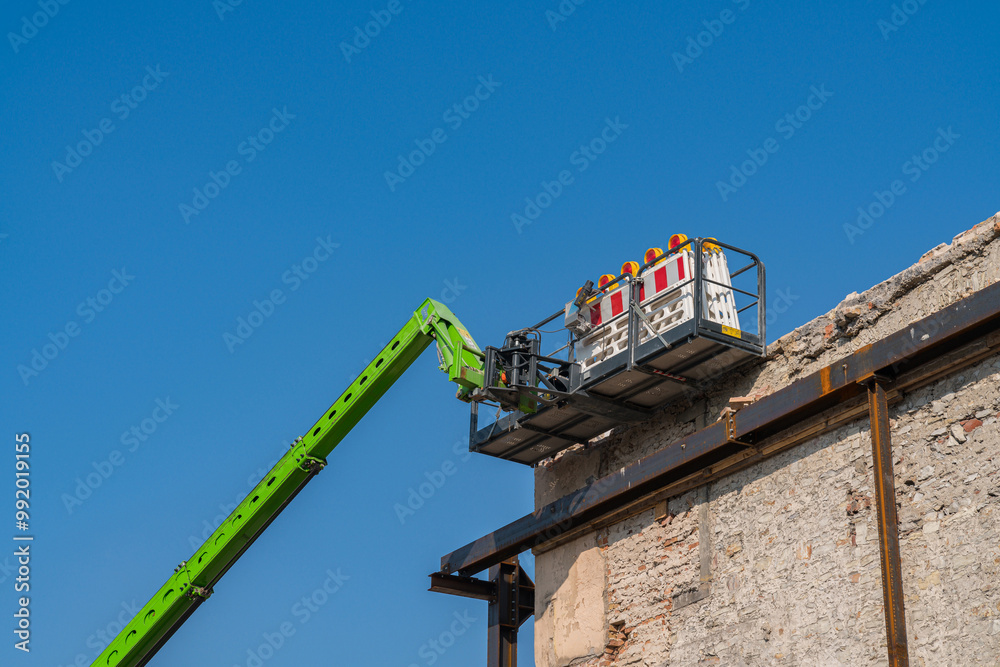 A lift cabin near the wall of a building under restoration. A lift cabin near the wall of a building under restoration.