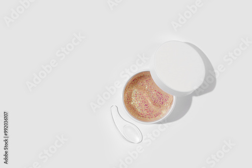 Hydrogel patches for moisturizing and nourishing the skin around the eyes. Cosmetic product in a jar on white background. Minimal cosmetic product concept photo