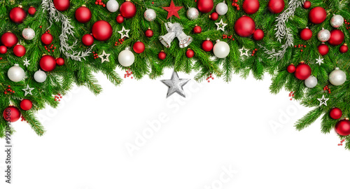 Arch shaped Christmas border isolated on white, composed of fresh fir branches and ornaments in red and silver, with a star in the middle