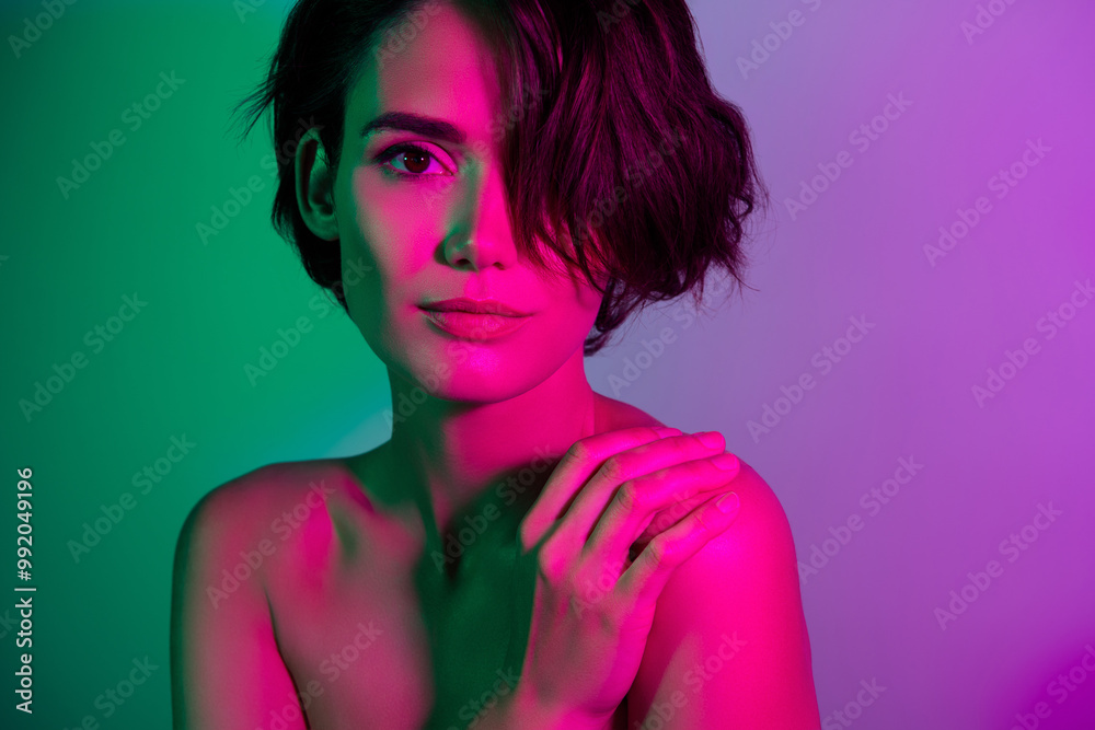 Photo of attractive girl with brown hair curls look touch hand shoulder isolated multicolor background Photo of attractive girl with brown hair curls look touch hand shoulder isolated multicolor background