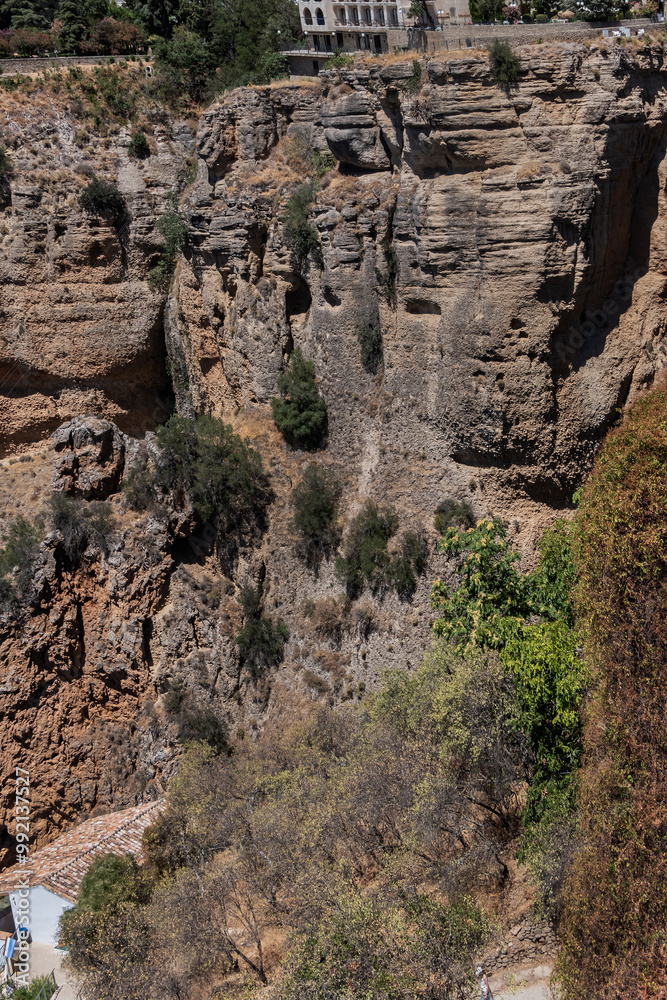 The rocky, sheer-sided limestone cliffs of Ronda Gorge (El Tajo de Ronda) plummet 390 feet (120 meters) to Guadalevin River. Ronda, Province of Malaga, Spain. The rocky, sheer-sided limestone cliffs of Ronda Gorge (El Tajo de Ronda) plummet 390 feet (120 meters) to Guadalevin River. Ronda, Province of Malaga, Spain.