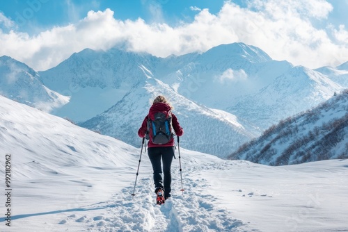 Woman hiking on snow covered mountain path in winter