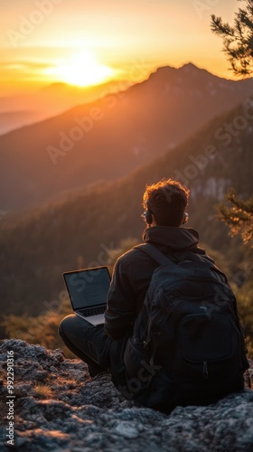 Digital nomad working on laptop at a scenic mountain overlook during sunset