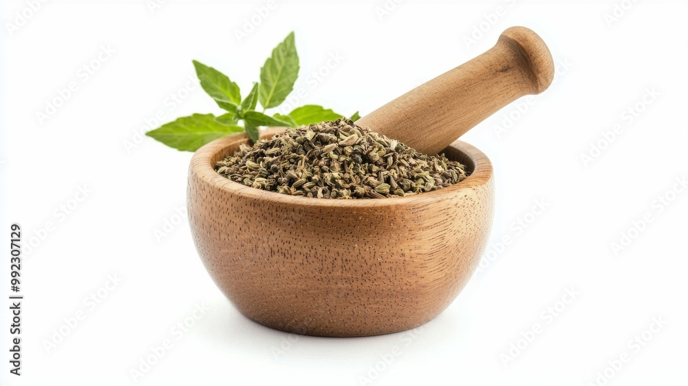A wooden bowl filled with herbs and a wooden pestle A wooden bowl filled with herbs and a wooden pestle