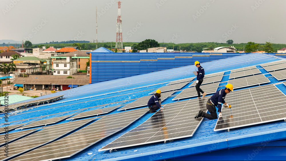 Naklejka premium Worker Technicians are working to construct solar panels system on roof. Installing solar photovoltaic panel system. Men technicians walking on roof structure to check photovoltaic solar modules.
