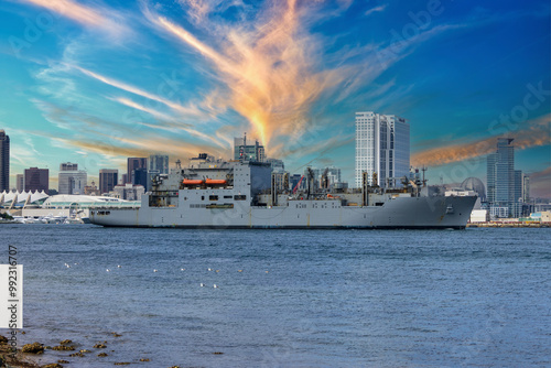 A large ship sailing, skyscrapers, office buildings, the San Diego Convention Center along the coast of the San Diego Bay at Coronado Tidelands Park in Coronado California USA