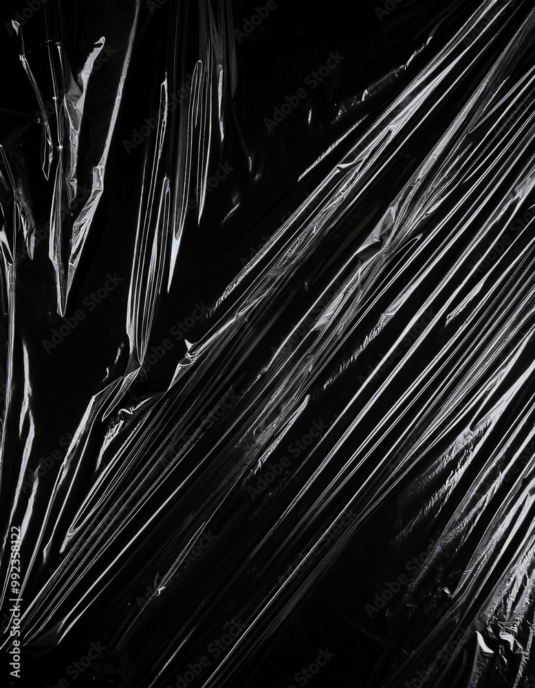 Obraz premium Transparent plastic wrap on the black background. Clean blank texture overlay effect template. Isolated wrinkle surface branding mock-up.