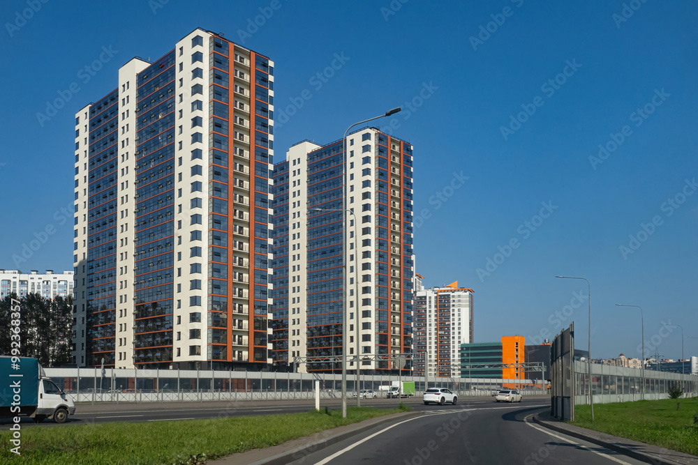Multi-storey residential buildings. Highway in densely populated city. Multi-storey buildings under blue sky. Modern architecture. Road junction of megapolis watches. Multi-storey residential buildings. Highway in densely populated city. Multi-storey buildings under blue sky. Modern architecture. Road junction of megapolis watches.