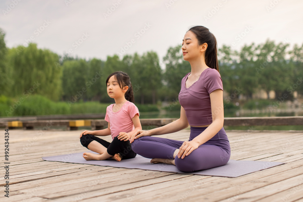 Mom And Daughter Doing Yoga In A Park Mom And Daughter Doing Yoga In A Park