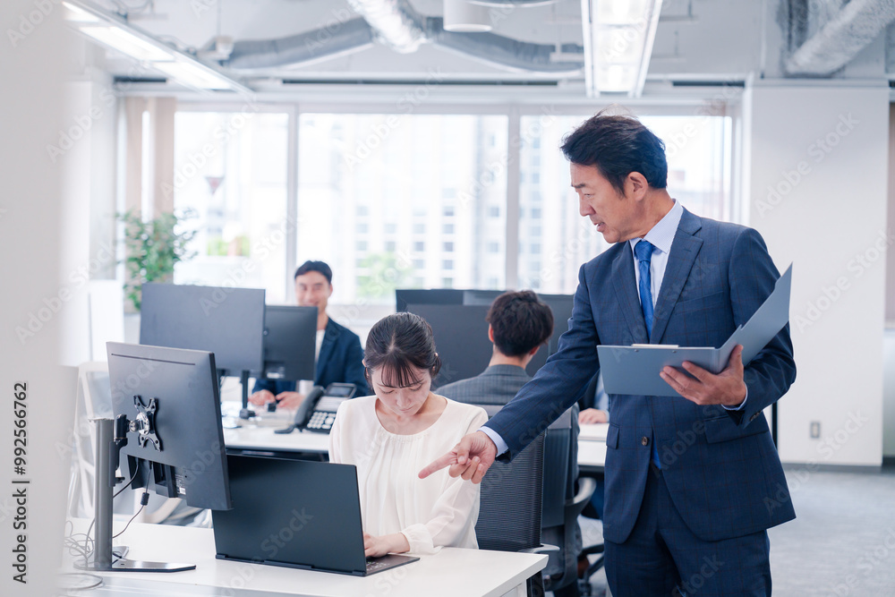 オフィスで上司から叱責をされる若い女性社員 オフィスで上司から叱責をされる若い女性社員