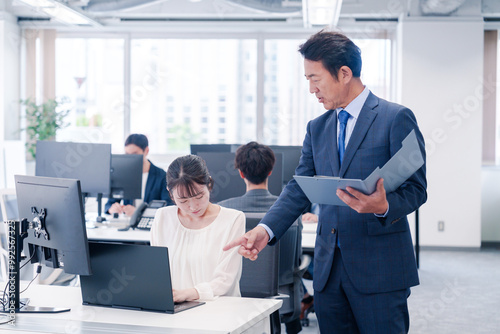 オフィスで上司から叱責をされる若い女性社員 photo