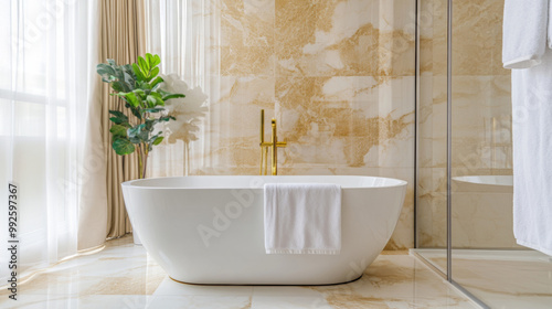 Luxury bathroom with a free standing bathtub, with gold features and elegant marble floor and wall. photo