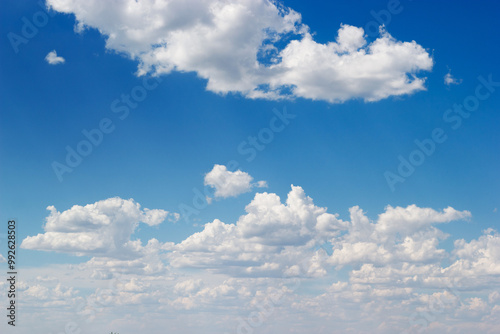 An azure sky filled with fluffy white cumulus clouds stretches.